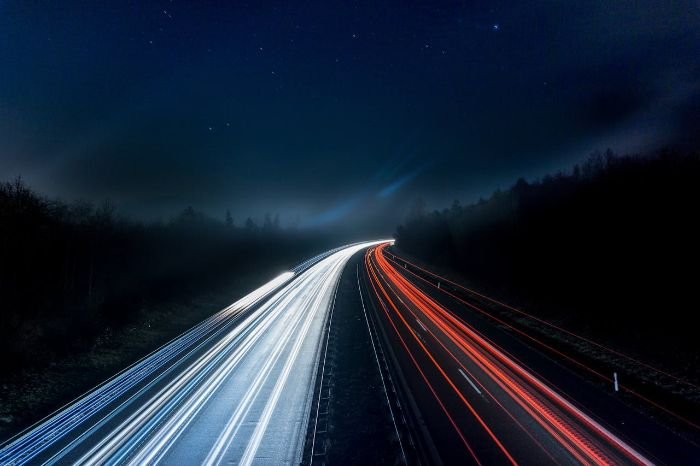 Long-exposure photo of a highway at night, representing the potential of piezoelectric roads to generate energy from vehicle movement.
