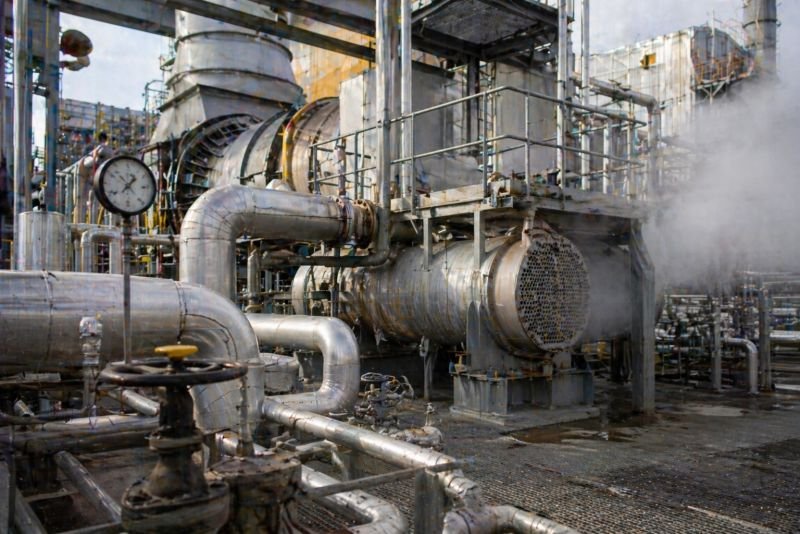 Gas turbine exhaust heat exchanger with insulated pipes, valves, gauges, and warm vapor in a power plant service area