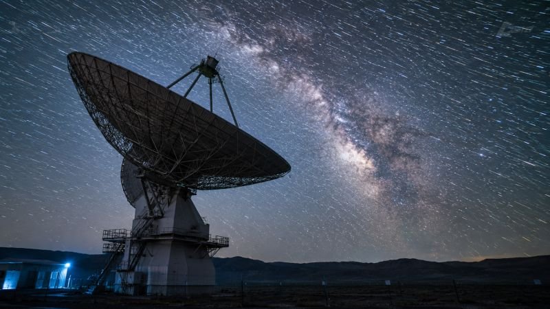 Radio telescope under the Milky Way showing the cosmic scale behind dark matter as an invisible fuel source