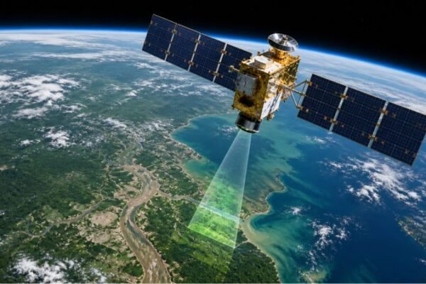 Earth observation satellite scanning a coastal landscape from orbit for environmental remote sensing and land surface monitoring.
