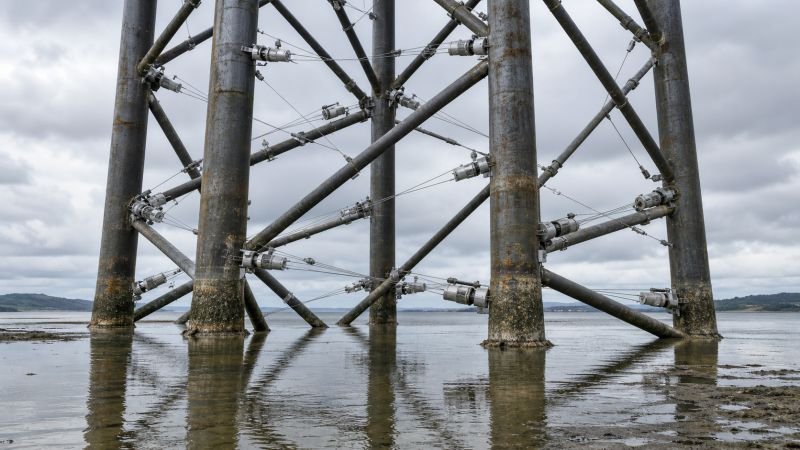 Karman vortex cable devices mounted across the cylindrical members of a steel-lattice offshore structure in shallow coastal water.
